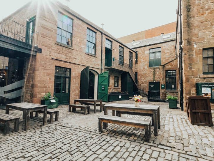 Verdant Works courtyard with picnic benches and green doors